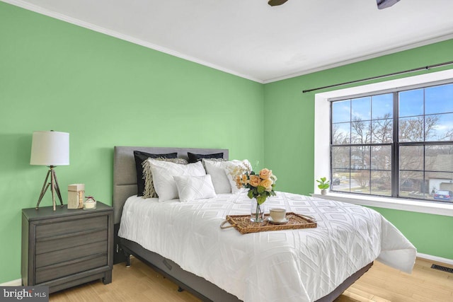 bedroom featuring light wood-type flooring and ornamental molding