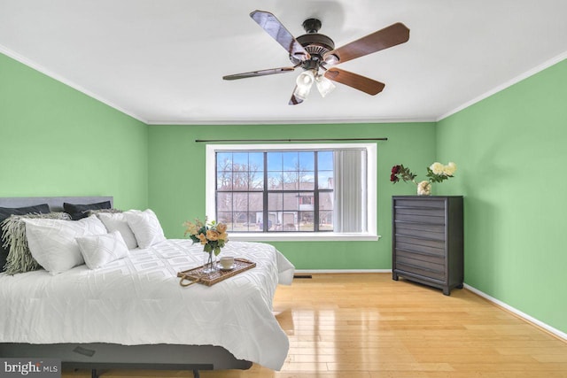 bedroom with ceiling fan, ornamental molding, and light hardwood / wood-style flooring