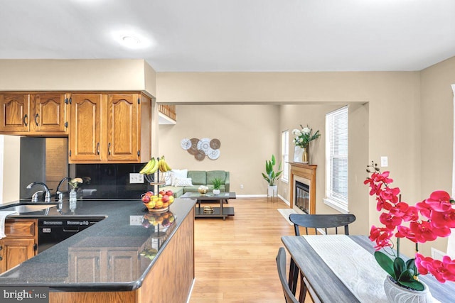 kitchen with light hardwood / wood-style flooring, black dishwasher, and sink