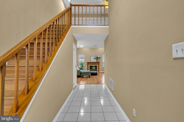 stairs featuring a high ceiling and tile patterned flooring