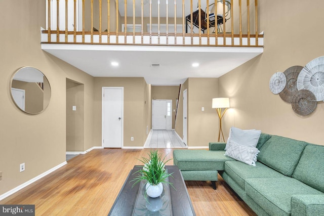 living room featuring a towering ceiling and hardwood / wood-style flooring