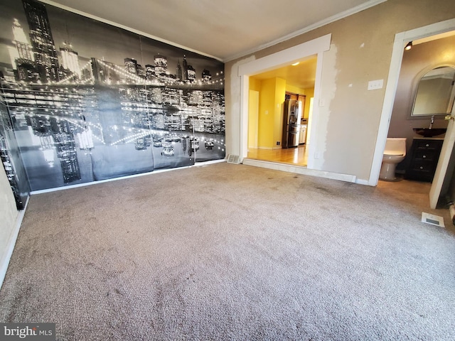 empty room featuring carpet floors and ornamental molding