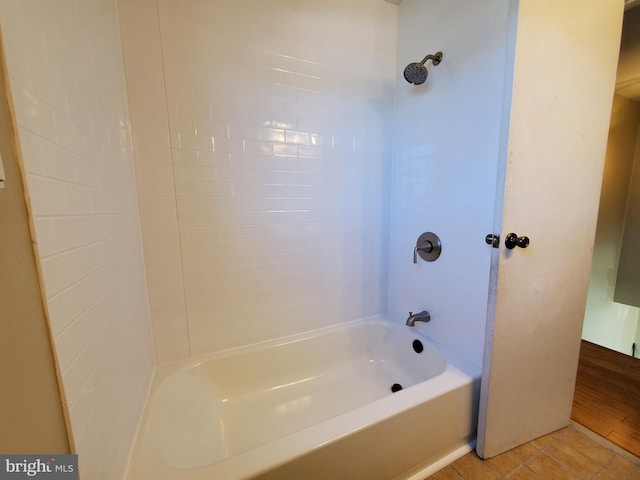 bathroom with tile patterned floors and washtub / shower combination