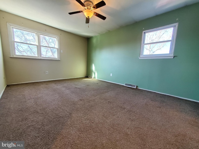 carpeted empty room with ceiling fan and plenty of natural light