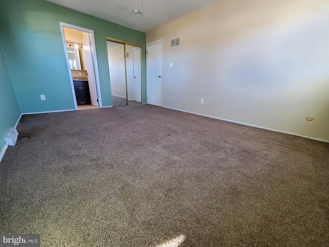 unfurnished bedroom with carpet floors and connected bathroom