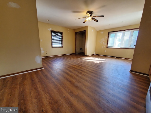 unfurnished room with ceiling fan and dark wood-type flooring