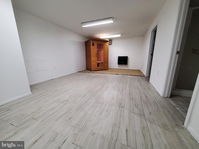 unfurnished living room featuring light wood-type flooring and heating unit