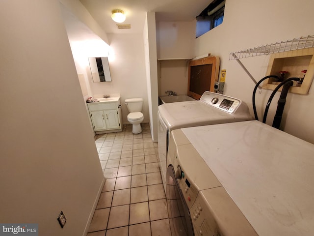 laundry room with independent washer and dryer, light tile patterned floors, and sink