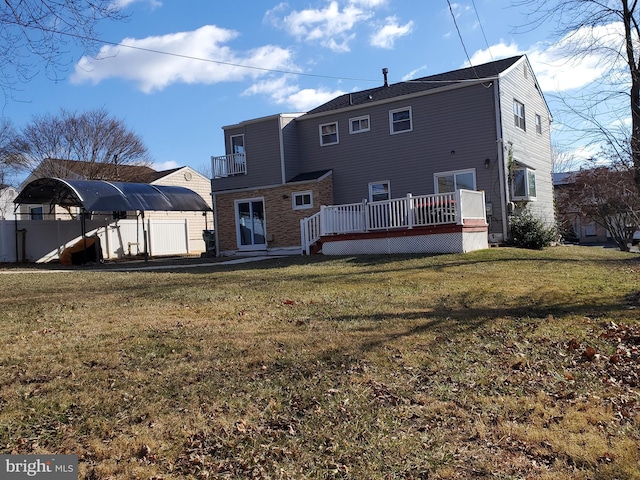 rear view of house with a yard and a wooden deck