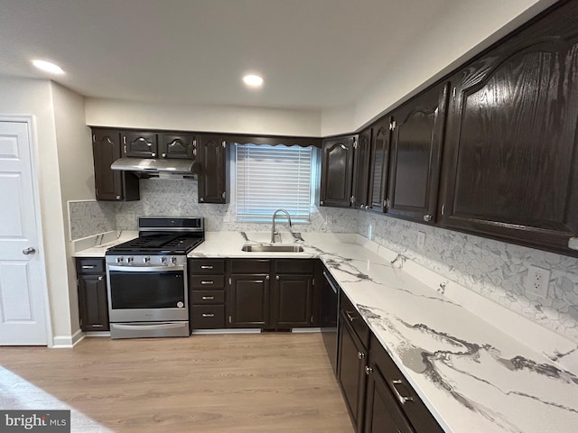 kitchen featuring tasteful backsplash, sink, stainless steel range with gas cooktop, and light hardwood / wood-style floors