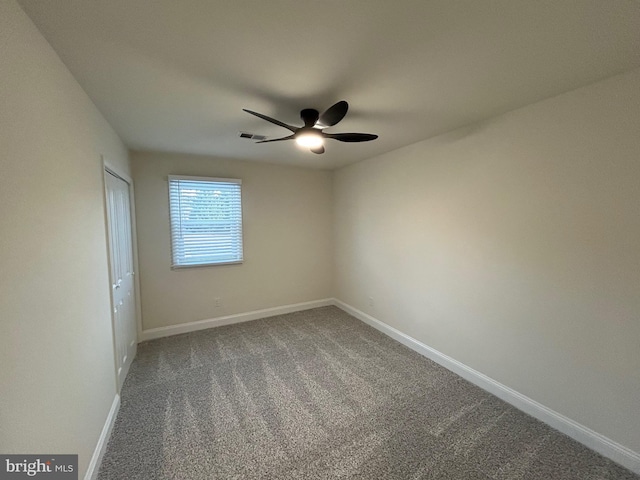 carpeted spare room featuring ceiling fan