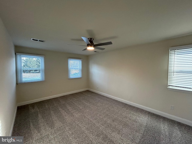 unfurnished room featuring ceiling fan, carpet, and a wealth of natural light