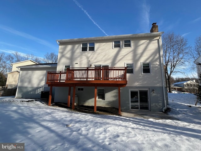 snow covered property with a wooden deck