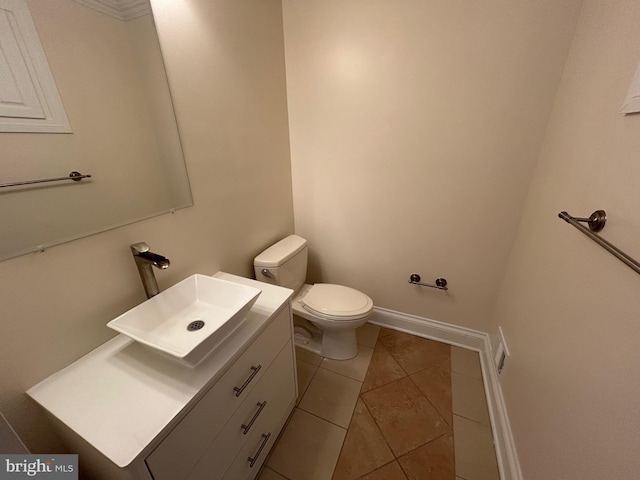 bathroom with toilet, tile patterned flooring, and vanity