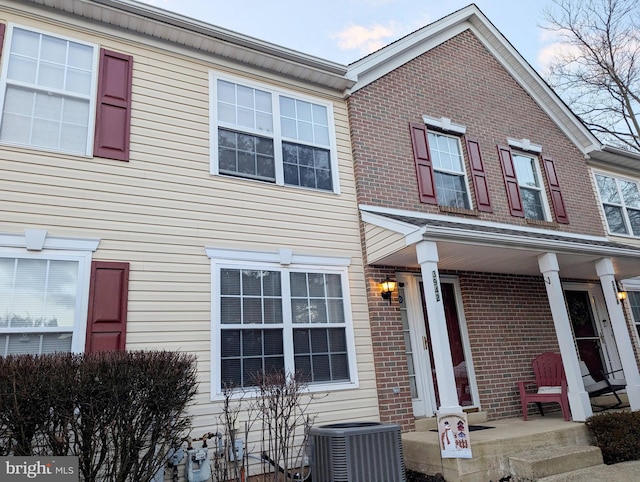 view of property featuring covered porch and central AC unit