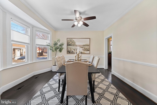 dining area featuring dark hardwood / wood-style flooring, ceiling fan, and crown molding