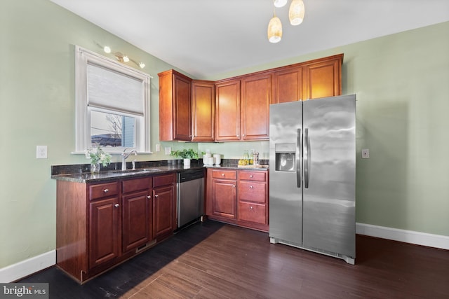 kitchen featuring sink, stainless steel appliances, pendant lighting, and dark wood-type flooring