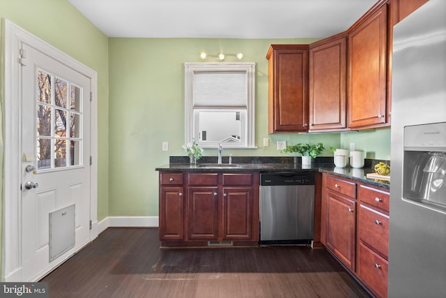 kitchen with sink, stainless steel appliances, dark stone counters, and dark hardwood / wood-style flooring