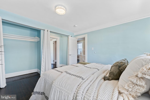 bedroom with ornamental molding and dark wood-type flooring