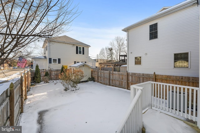 yard covered in snow with a storage unit