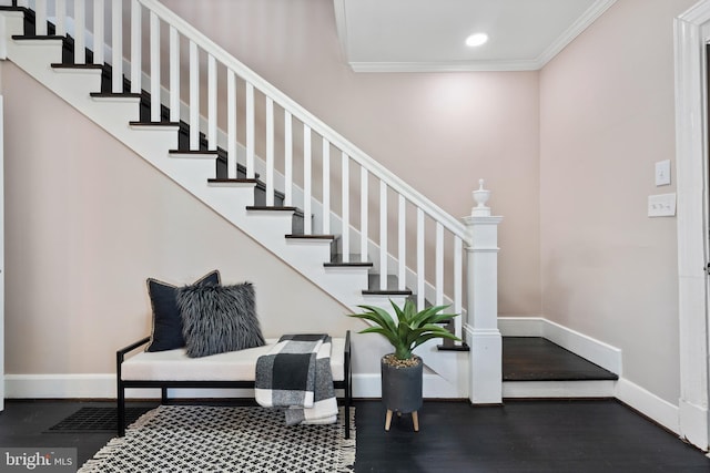 stairway featuring ornamental molding and wood-type flooring