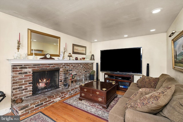 living room with recessed lighting, a fireplace, and wood finished floors