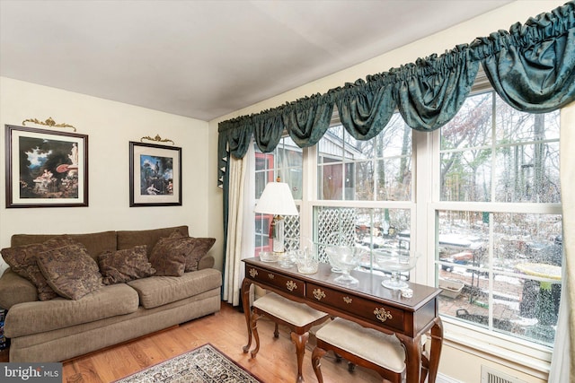 living area featuring visible vents and wood finished floors