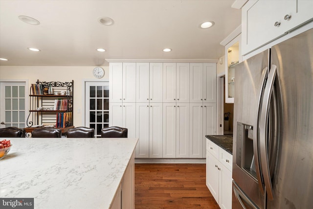 kitchen with white cabinets, light stone countertops, stainless steel refrigerator with ice dispenser, and dark wood-type flooring