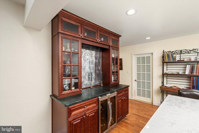 bar with beverage cooler, light wood-style flooring, and recessed lighting