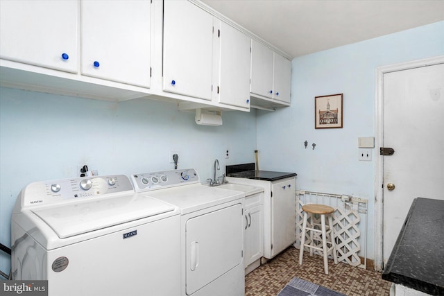 laundry area with cabinet space, a sink, and washing machine and clothes dryer