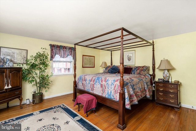 bedroom with baseboards and wood finished floors