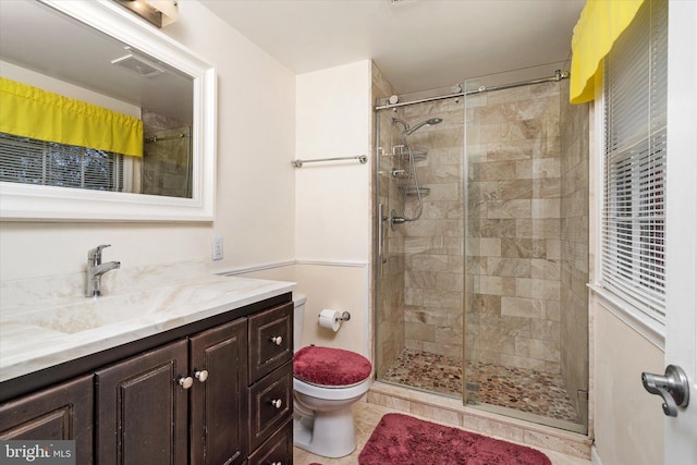 bathroom featuring toilet, a stall shower, visible vents, and vanity