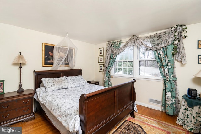 bedroom featuring light wood-style floors and visible vents