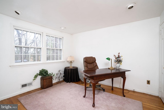 office featuring visible vents, baseboards, and wood finished floors