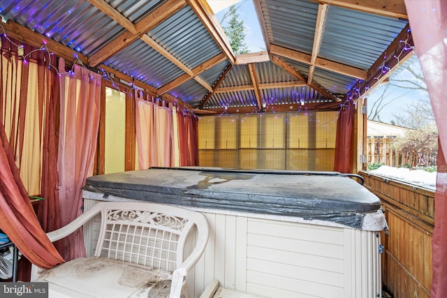 exterior space with a hot tub, fence, and a gazebo