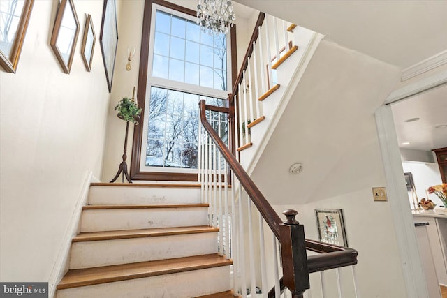 stairway with a notable chandelier