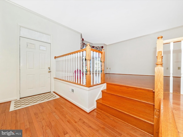 entryway featuring hardwood / wood-style floors and crown molding