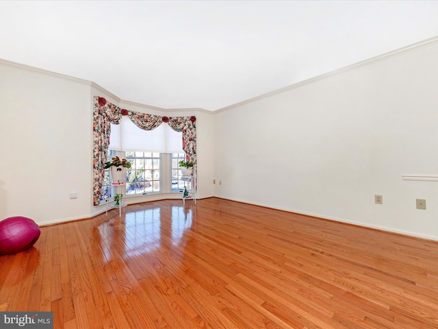 empty room with ornamental molding and light hardwood / wood-style flooring