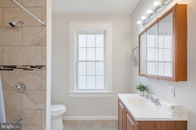 bathroom featuring toilet, plenty of natural light, and tiled shower