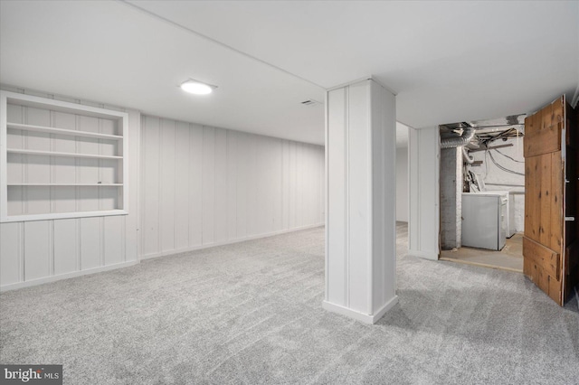 basement with light colored carpet and built in features