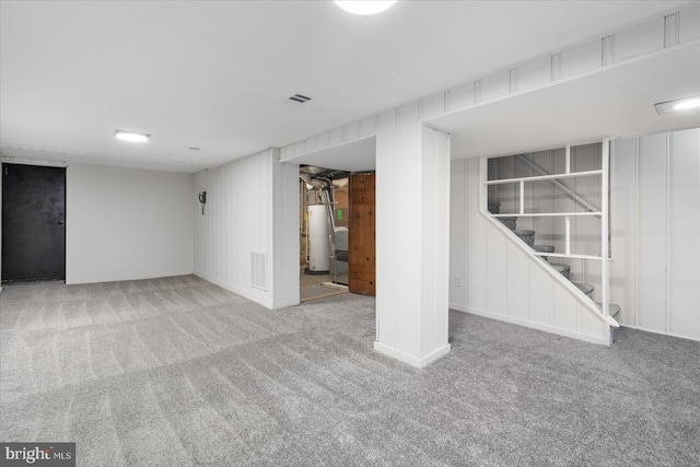 basement with water heater, wooden walls, and carpet flooring