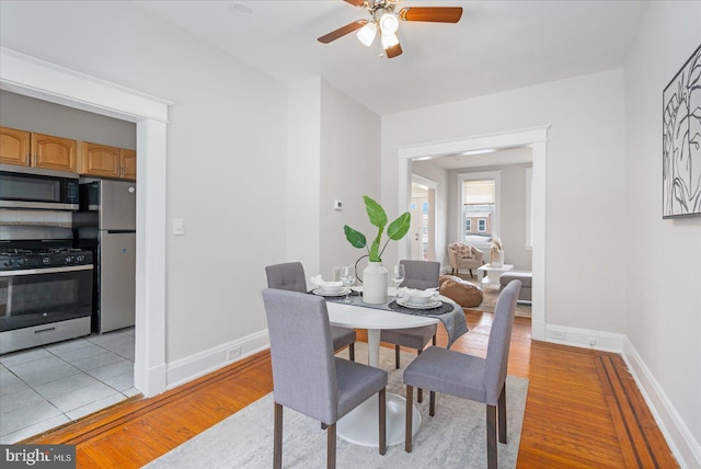 dining area with ceiling fan and light wood-type flooring