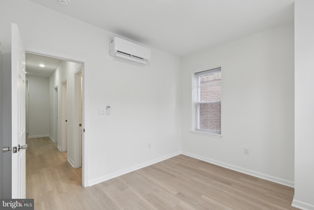 unfurnished room with light hardwood / wood-style floors and a wall mounted AC