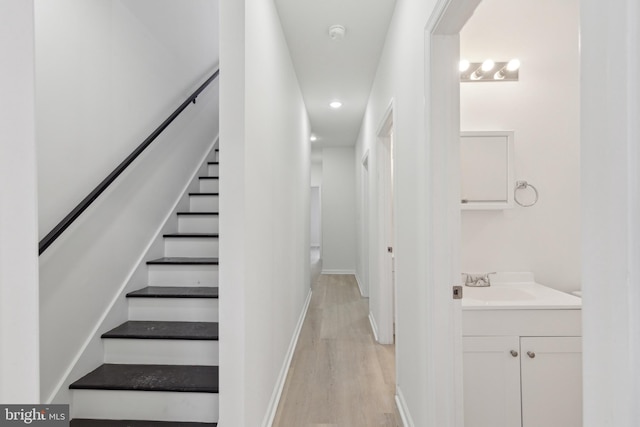 staircase featuring sink and wood-type flooring