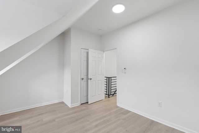 bonus room featuring light wood-type flooring and lofted ceiling