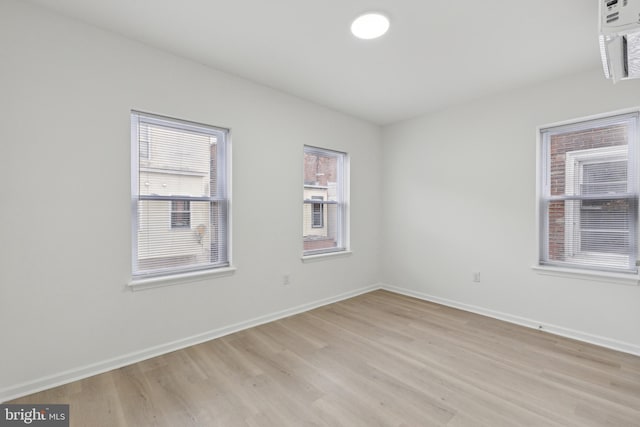 spare room featuring light hardwood / wood-style floors and plenty of natural light