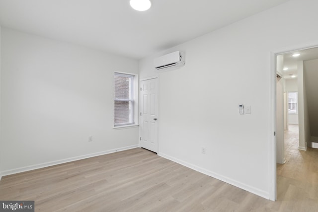 spare room with light hardwood / wood-style floors and a wall mounted air conditioner