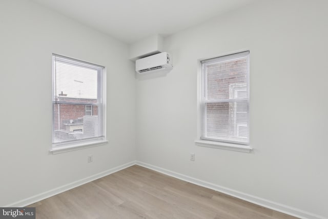 unfurnished room featuring light hardwood / wood-style floors and a wall mounted air conditioner