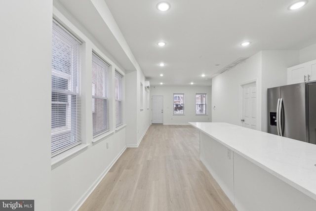 corridor with light hardwood / wood-style floors