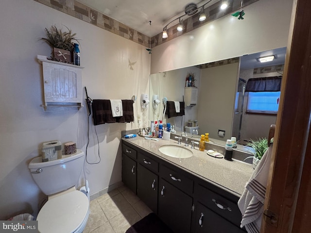 bathroom featuring vanity, tile patterned floors, and toilet